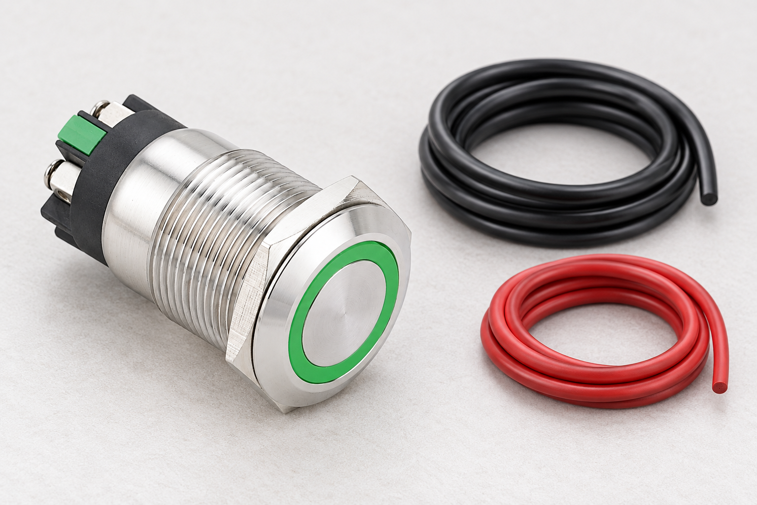 Reference-based illustration of a stainless ring-lit push button beside two disconnected cable coils