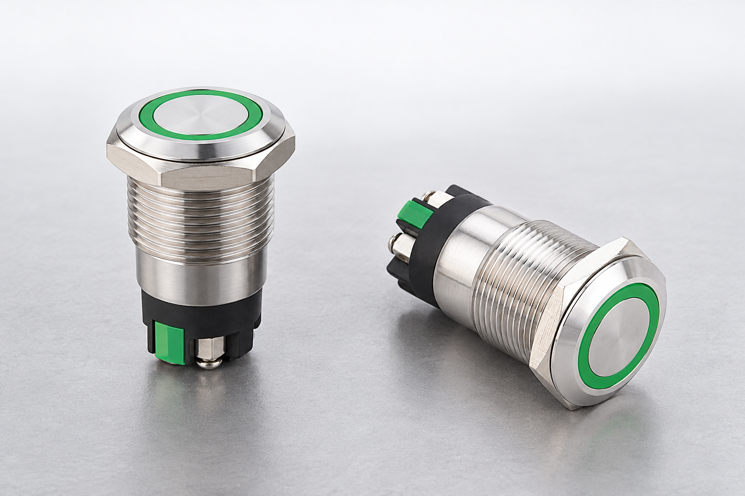 Two intact green-ring buttons representing separate operator stations