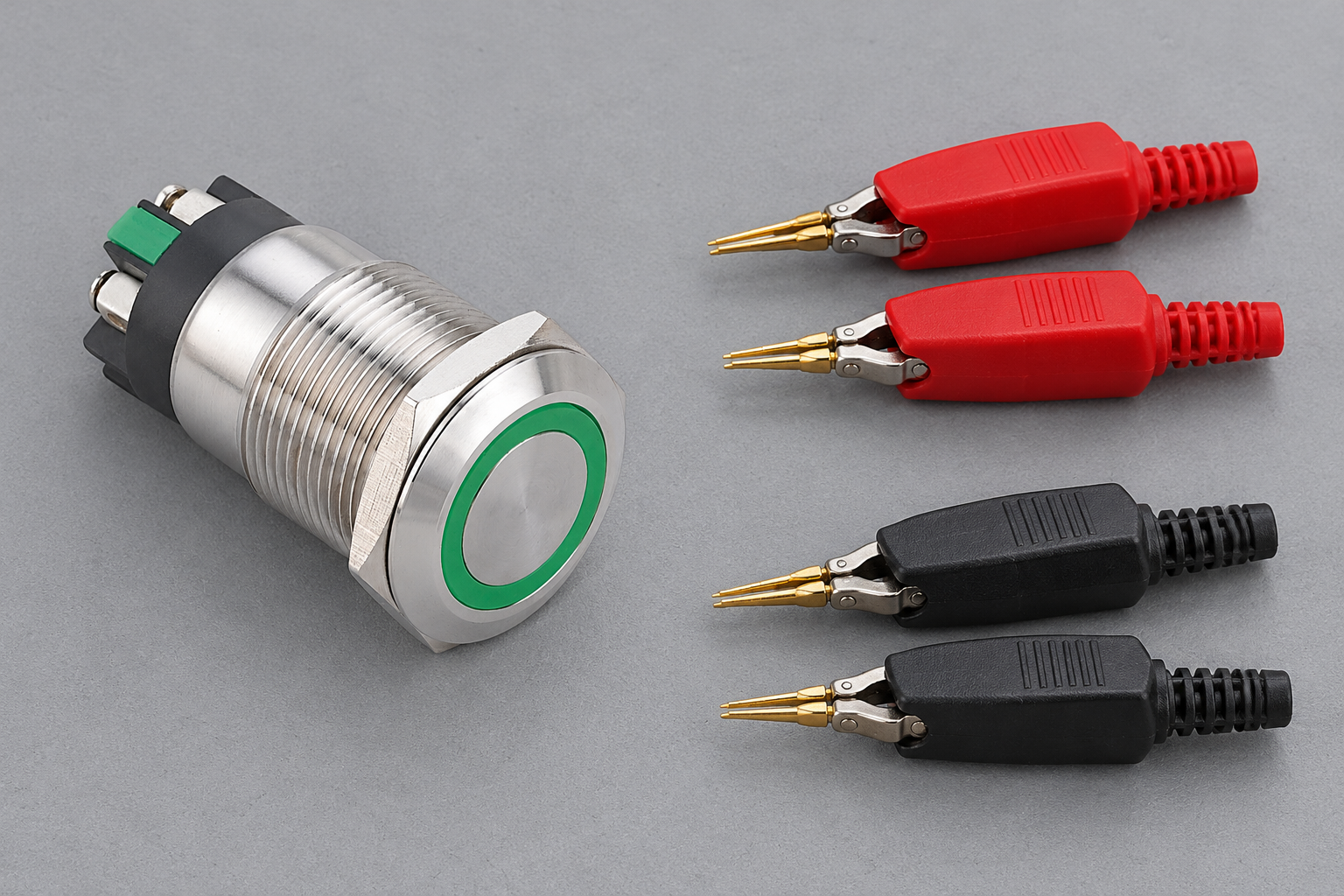 Metal push button beside separate red and black test clips
